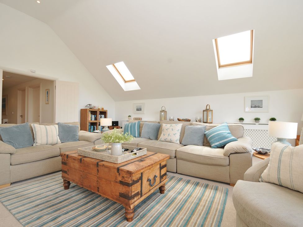 A living room with a coffee table and bookshelves at Farlands Daymer Bay