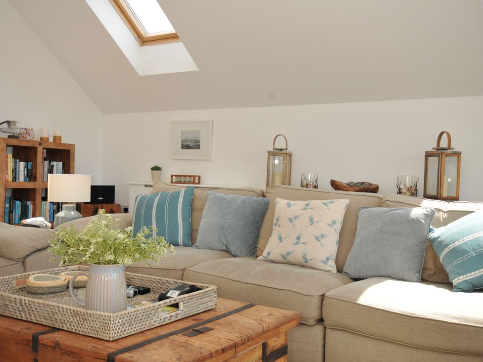 A living room with a couch and coffee table at Farlands in Daymer Bay