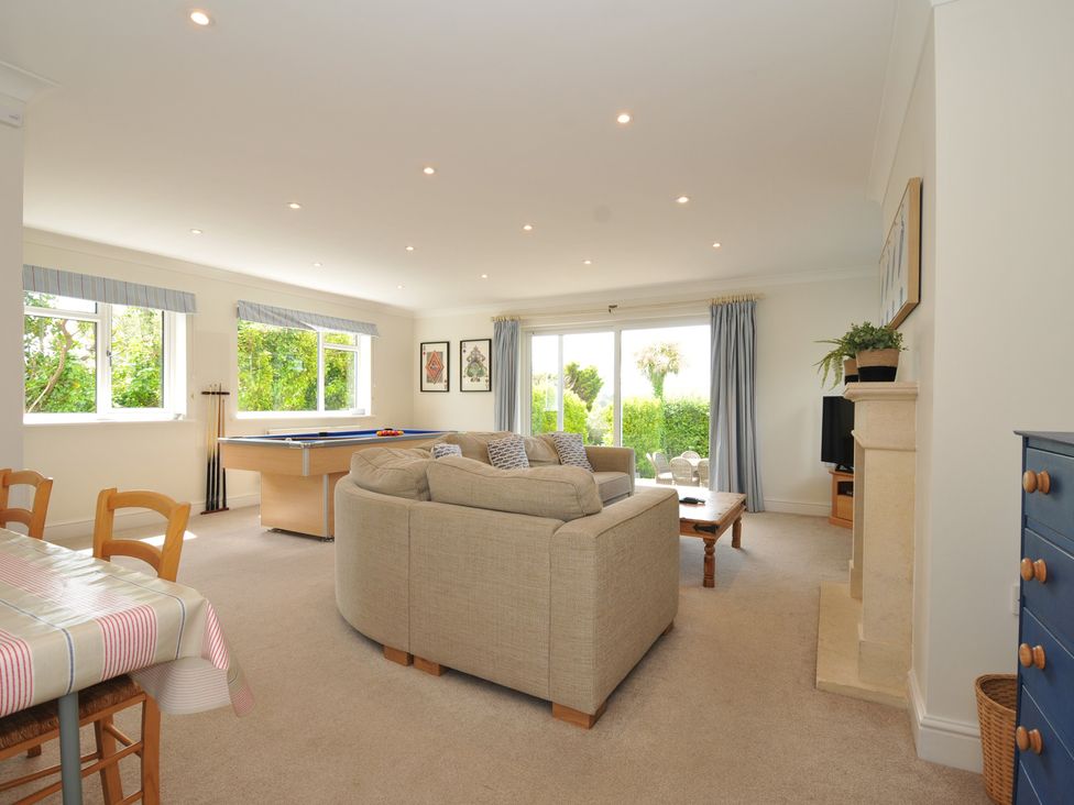 A living room with a sofa and pool table at Farlands in Daymer Bay