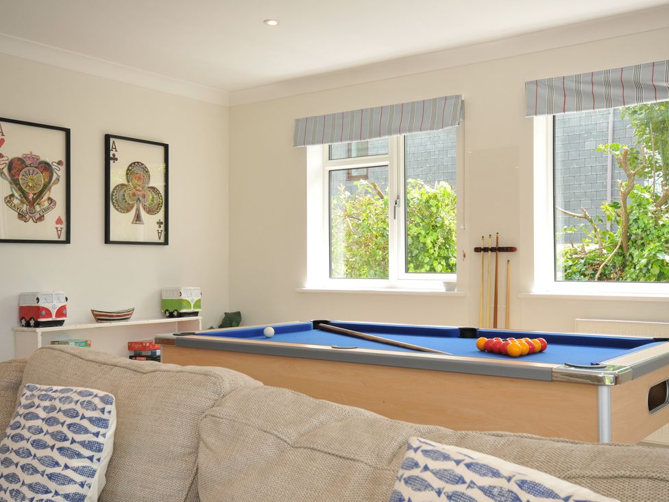 A snug room featuring a pool table and shelves at Farlands in Daymer Bay
