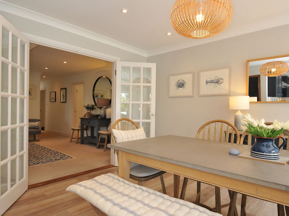 A dining room with a table and chairs at Farlands in Daymer Bay
