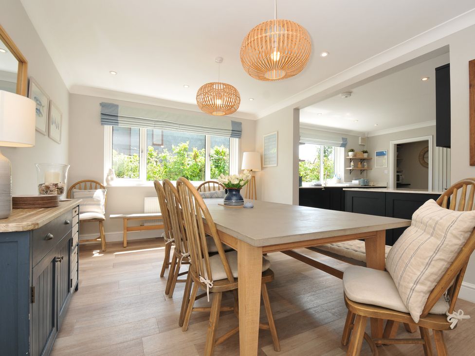 A dining room with a table and chairs at Farlands in Daymer Bay