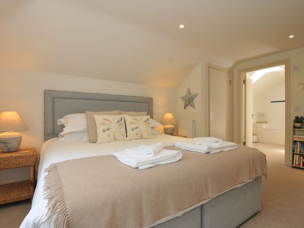 A bedroom with a bed and a lamp at Farlands Daymer Bay