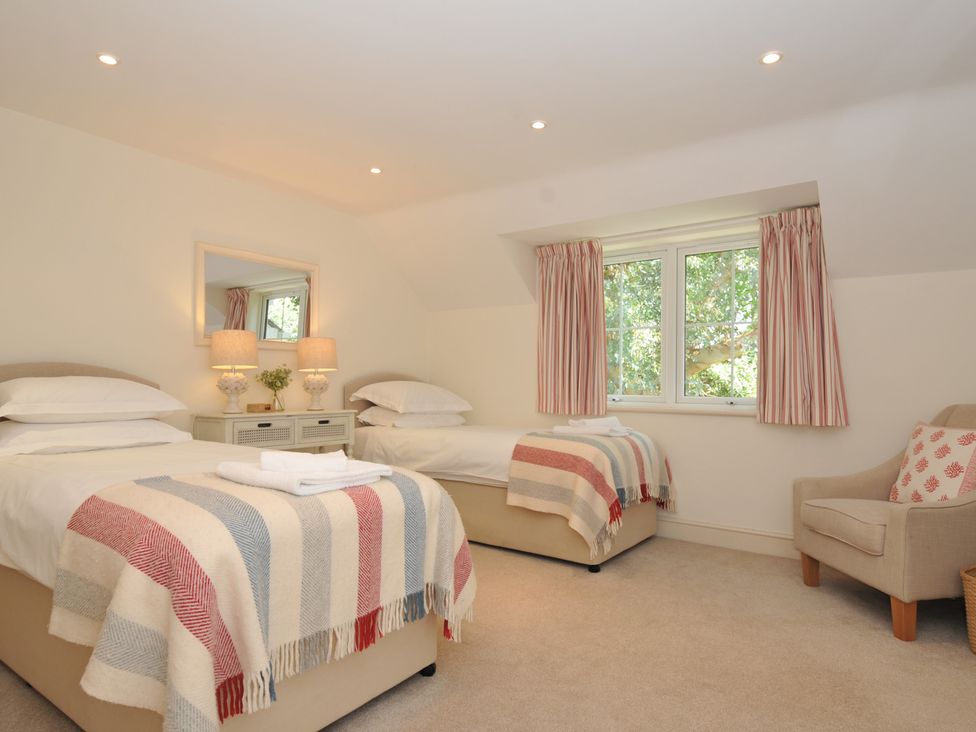 A bedroom with two beds and a window at Farlands Daymer Bay