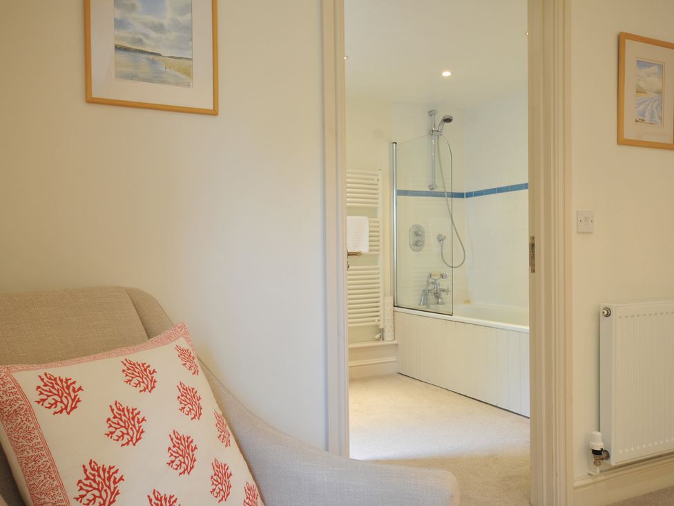 A view of a bathroom with a bathtub and shower from a living area at Farlands in Daymer Bay