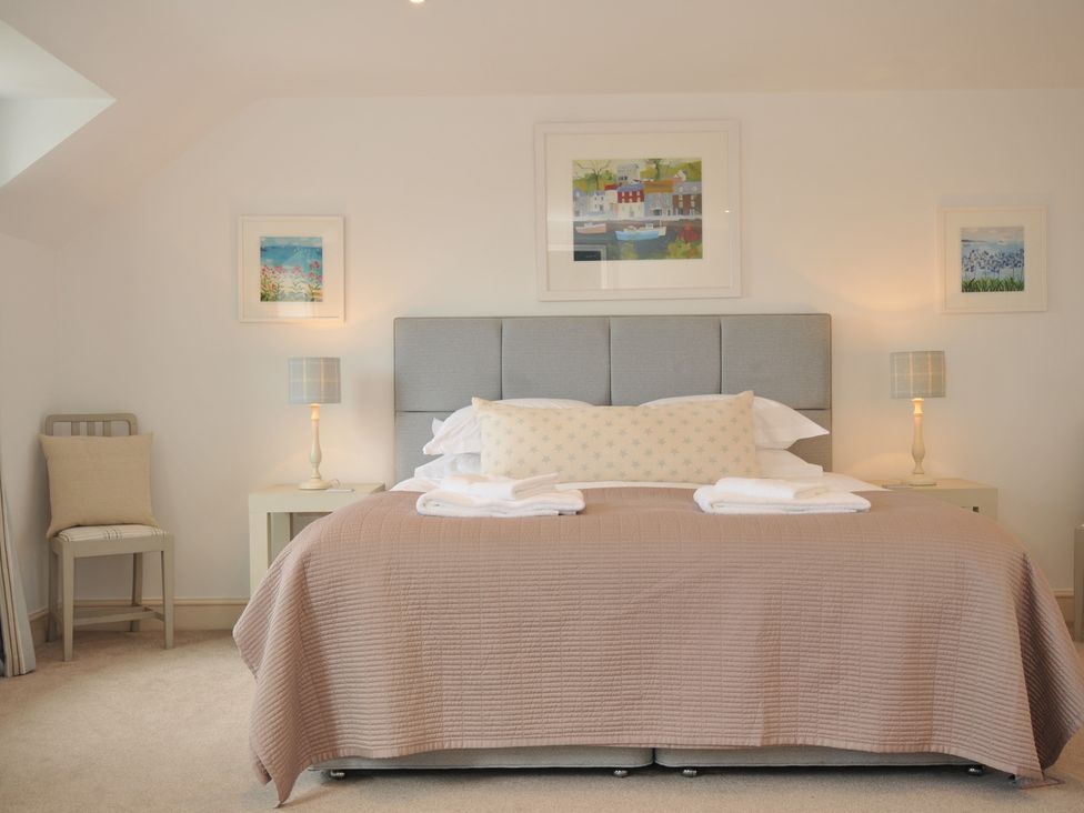 A bedroom with a bed and paintings at Farlands in Daymer Bay