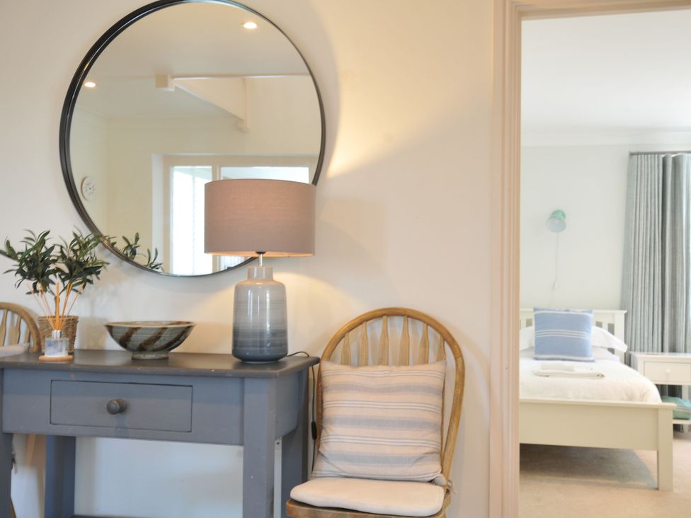 A bedroom with a console table and lamp at Farlands in Daymer Bay