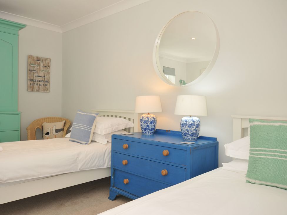 A bedroom with two beds and a blue dresser at Farlands in Daymer Bay