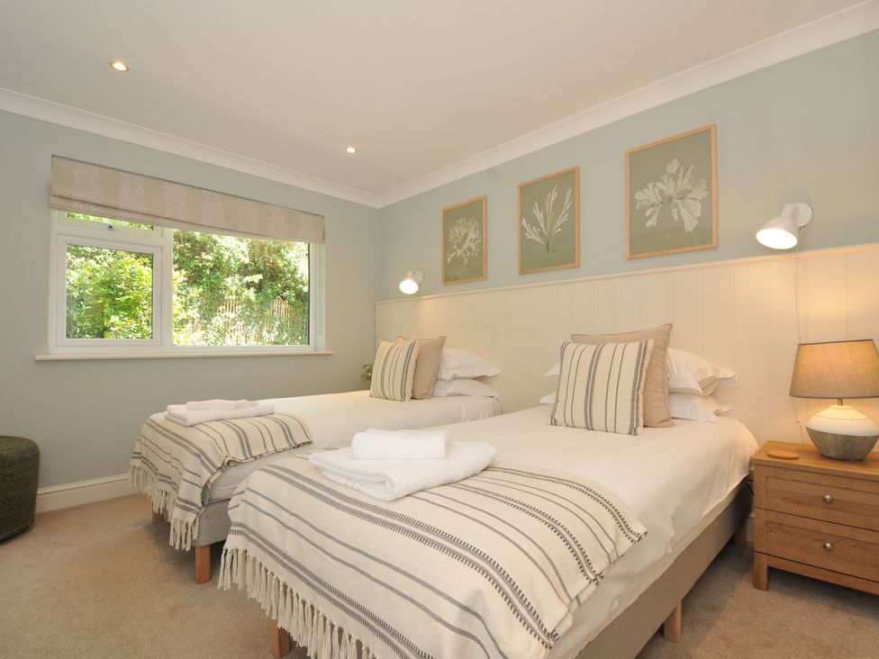 A bedroom with twin beds and a nightstand at Farlands in Daymer Bay