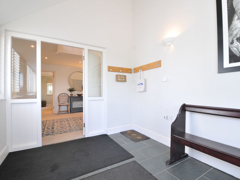 An entrance hall with a bench and coat hooks at Farlands in Daymer Bay