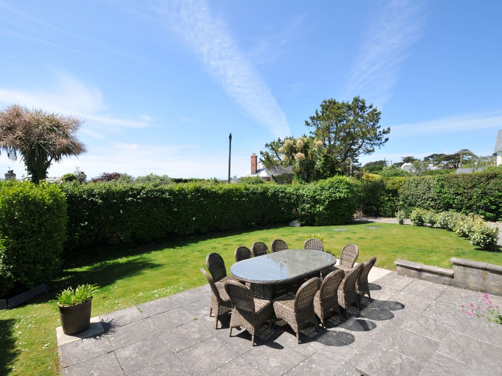 A garden with a patio table and chairs at Farlands in Daymer Bay