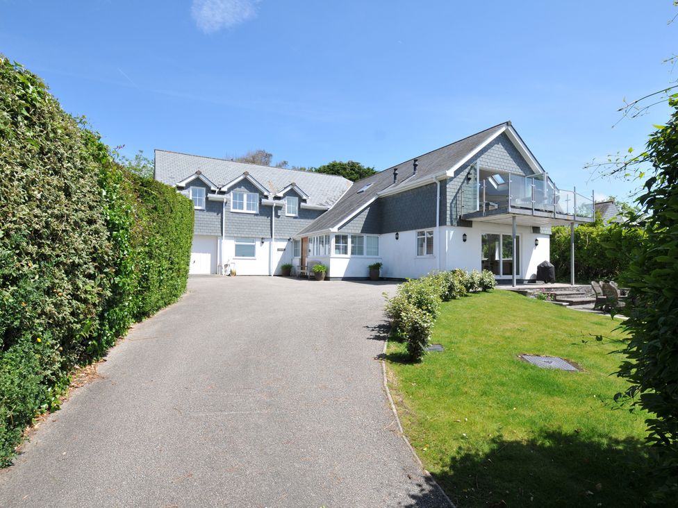 An outdoor view of a house with a driveway and garden at Farlands in Daymer Bay