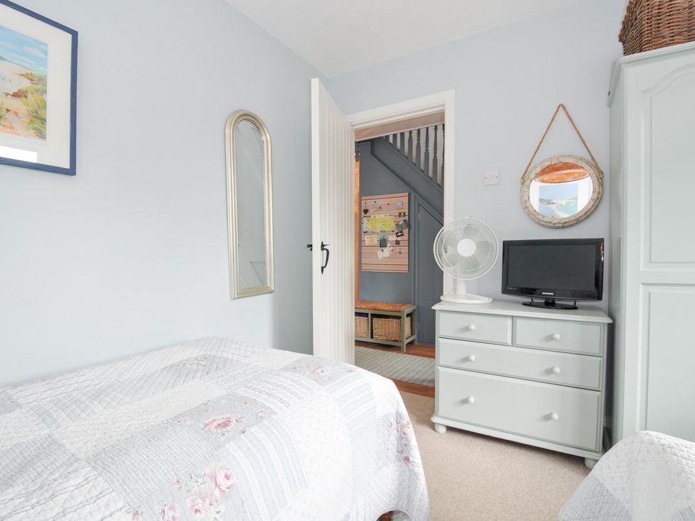 A bedroom with a bed, mirror, fan, and television at Rocklings, Rock