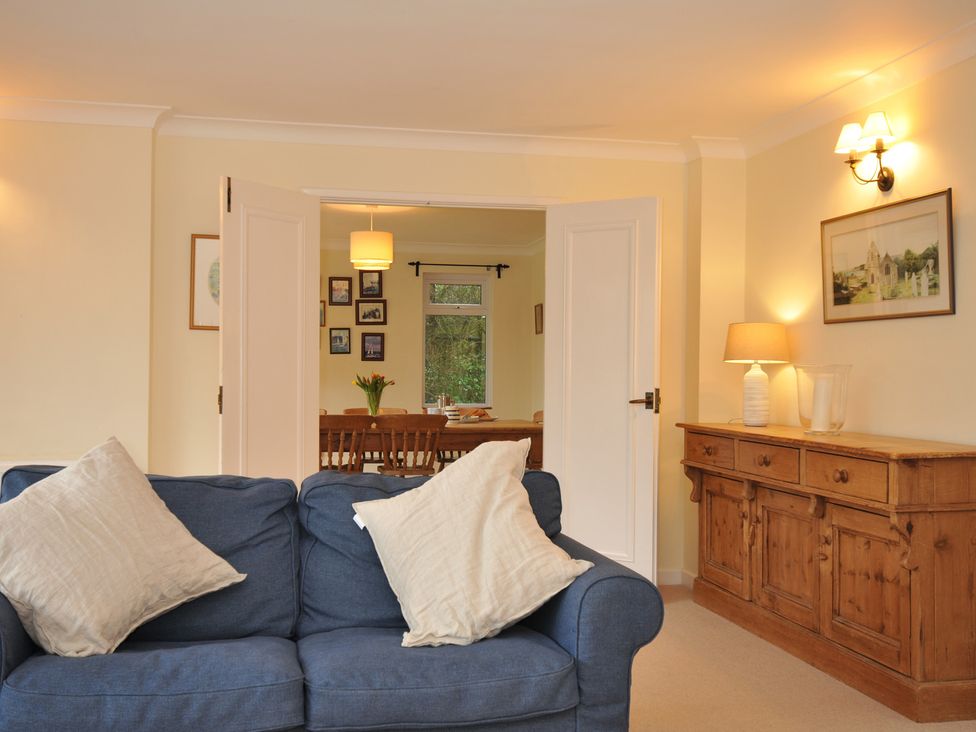 A living room with a sofa and a dining area at Tregillan Rock