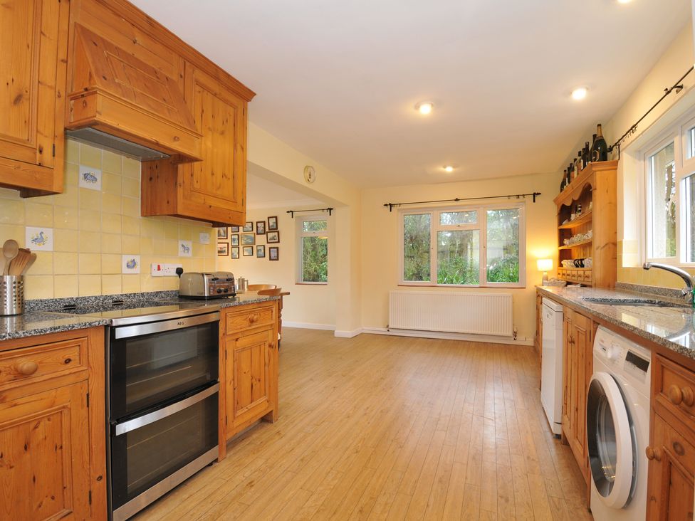 A kitchen with wooden cabinets and appliances at Tregillan in Rock