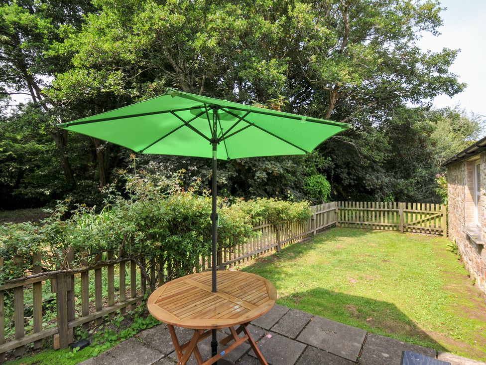 A garden with a table and umbrella at Mill Pond in Rock