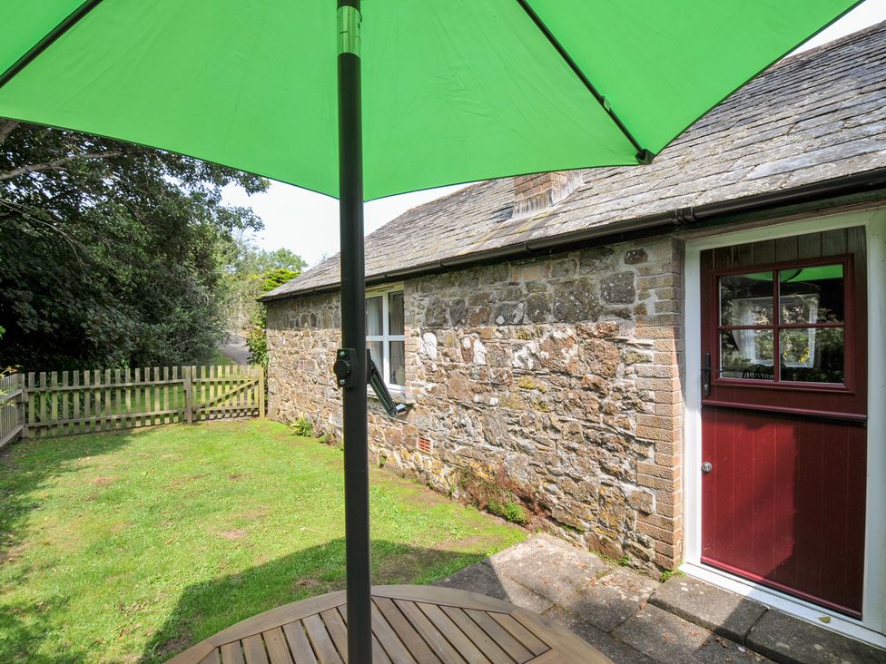 A garden with a wooden table and green umbrella at Mill Pond Rock