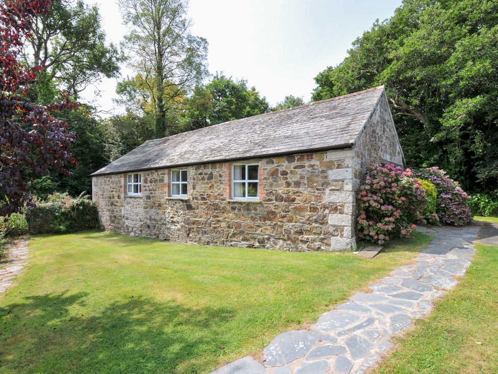 A stone building with windows in a garden at Mill Pond Rock