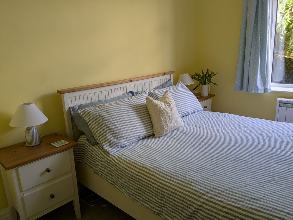 A bedroom with a bed and nightstand at Burwyn in Polzeath