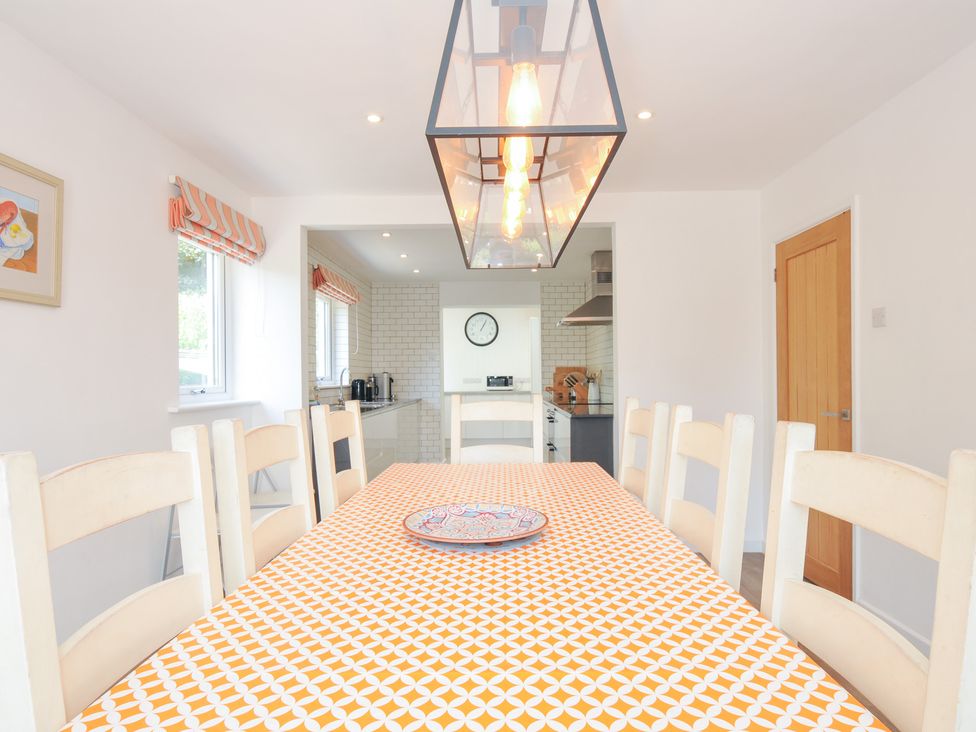 A dining room with a table and chairs at Porthilly Brook in Rock