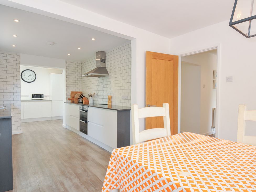 A kitchen with a dining table and chairs at Porthilly Brook in Rock