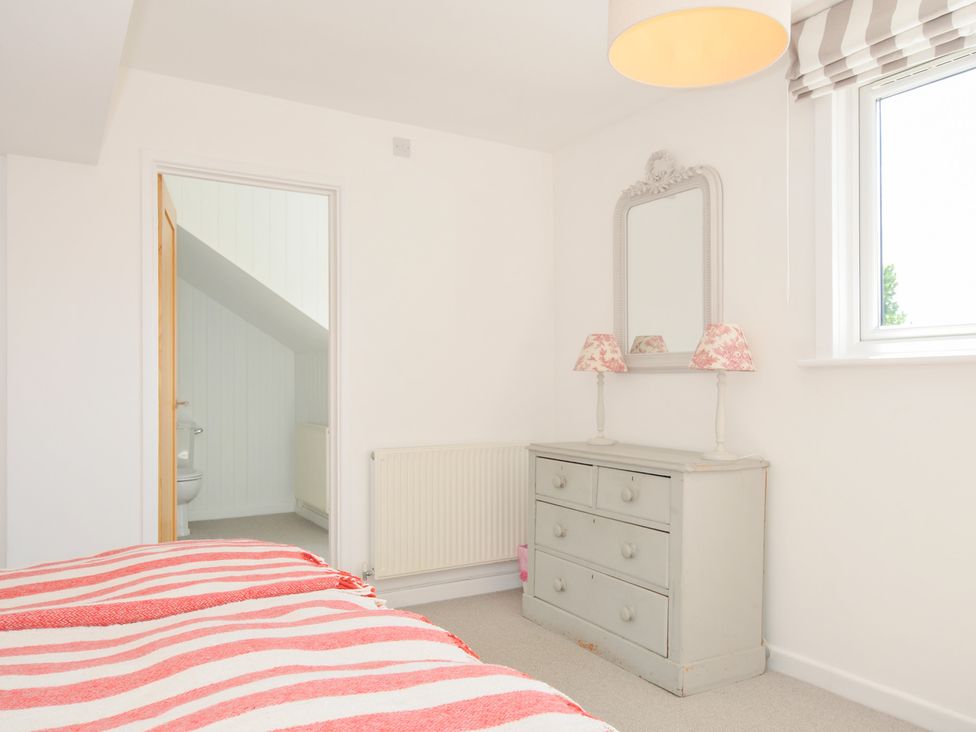 A bedroom with a bed and dresser at Porthilly Brook in Rock