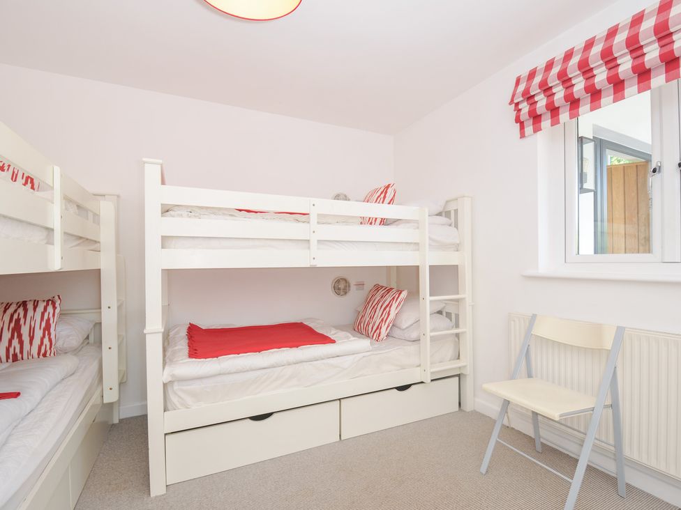 A bedroom with bunk beds and a chair at Porthilly Brook in Rock
