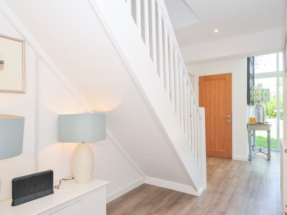 A hallway with a staircase and lamps at Porthilly Brook in Rock