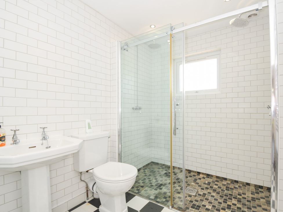 A bathroom with a shower, toilet, and sink at Porthilly Brook in Rock