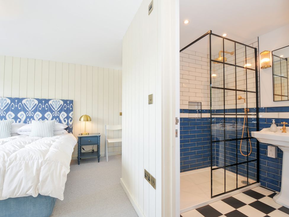 A bedroom with a bed and attached shower area at Porthilly Brook in Rock
