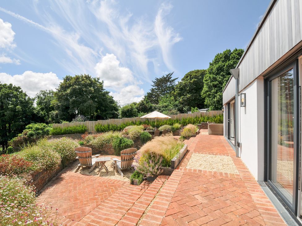 A garden with chairs and a table at Porthilly Brook in Rock