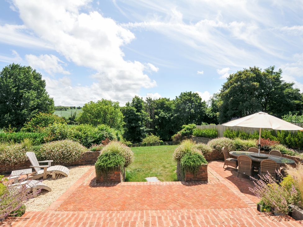 A garden with a patio and seating area at Porthilly Brook in Rock