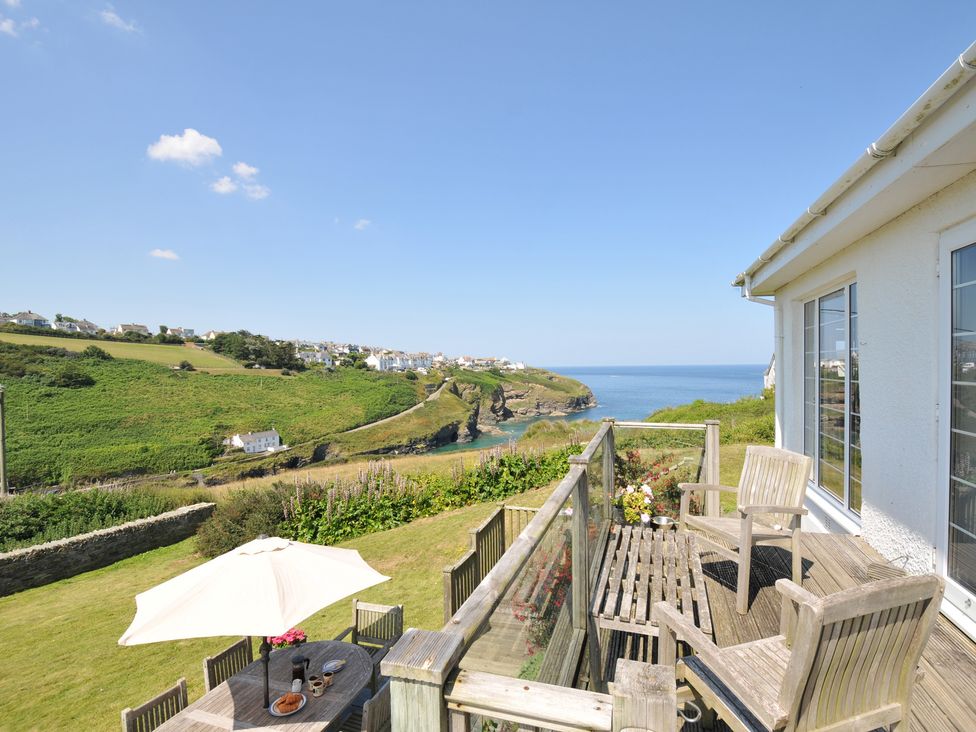 A terrace with a table and chairs overlooking the ocean at Cartway Cove, Port Isaac