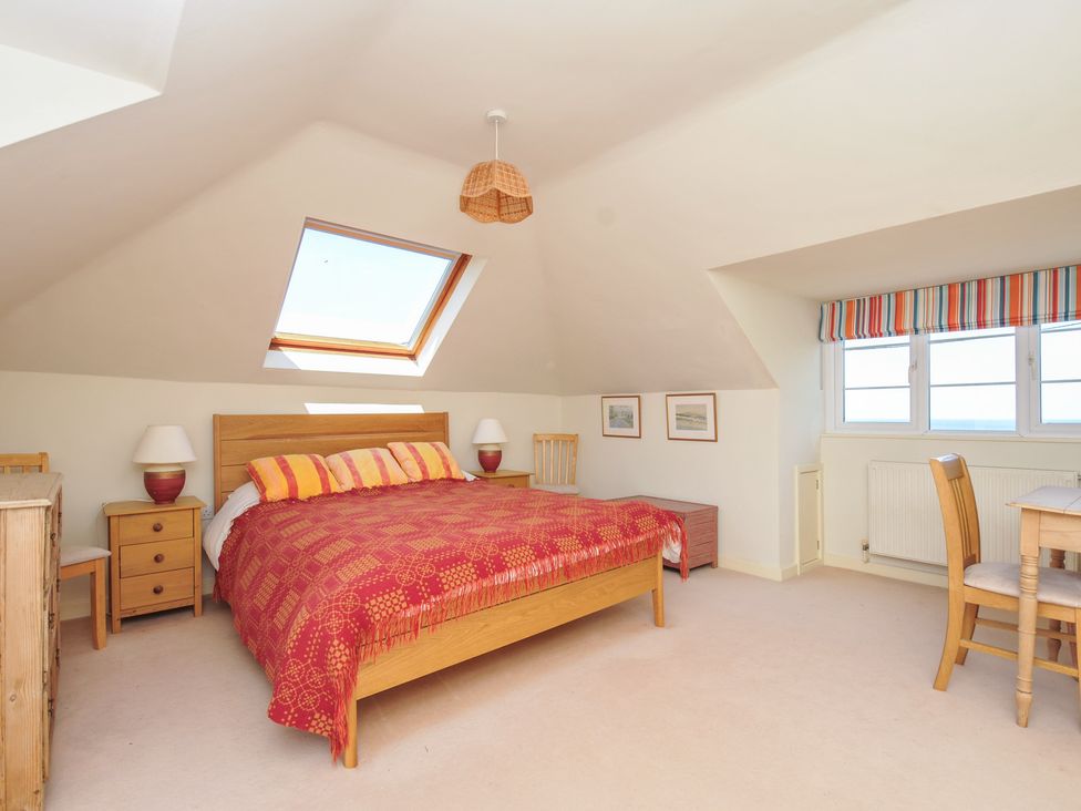 A bedroom with a bed and furniture at Cartway Cove, Port Isaac