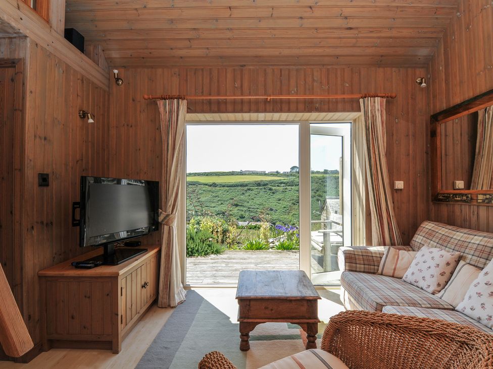 A living room with a television and sofa at Cartway Cabin in Port Isaac