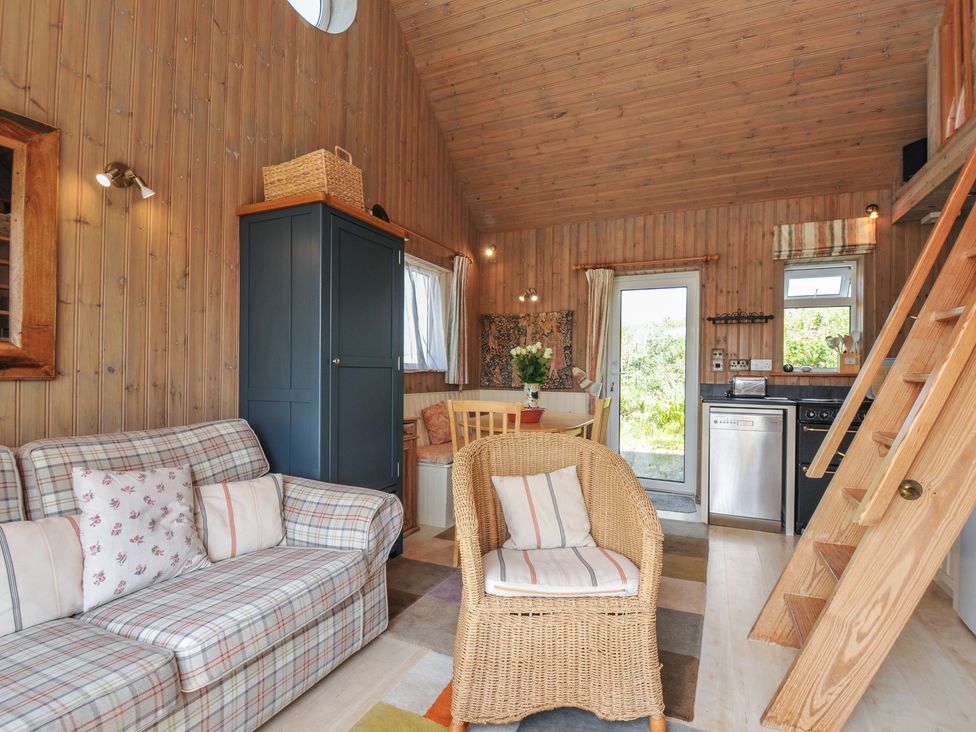 A living room with a sofa and dining table at Cartway Cabin Port Isaac