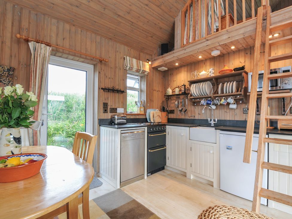 A kitchen with a table and chairs at Cartway Cabin in Port Isaac
