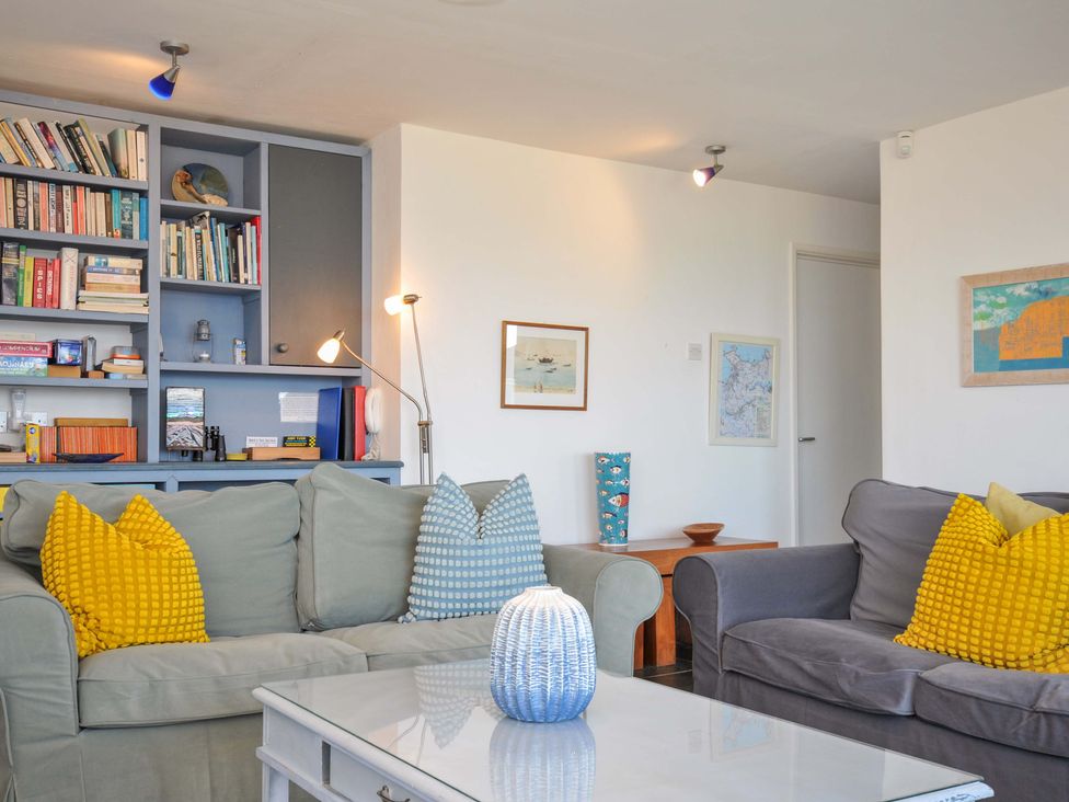 A living room with a bookshelf and seating area at Upper Gren in Trebetherick
