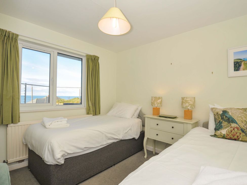 A bedroom with two beds and a window at Upper Gren in Trebetherick