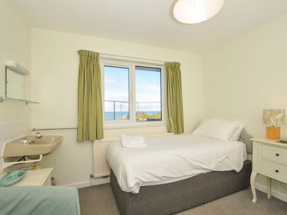 A bedroom with a bed and window at Upper Gren in Trebetherick