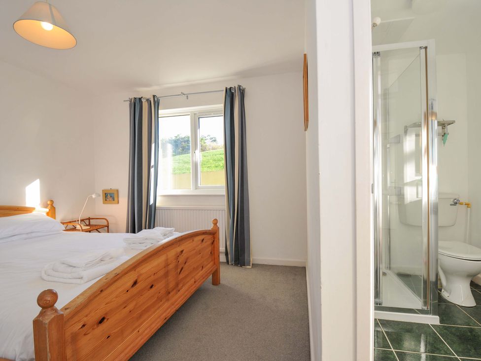A bedroom with a bed and a shower area at Upper Gren in Trebetherick