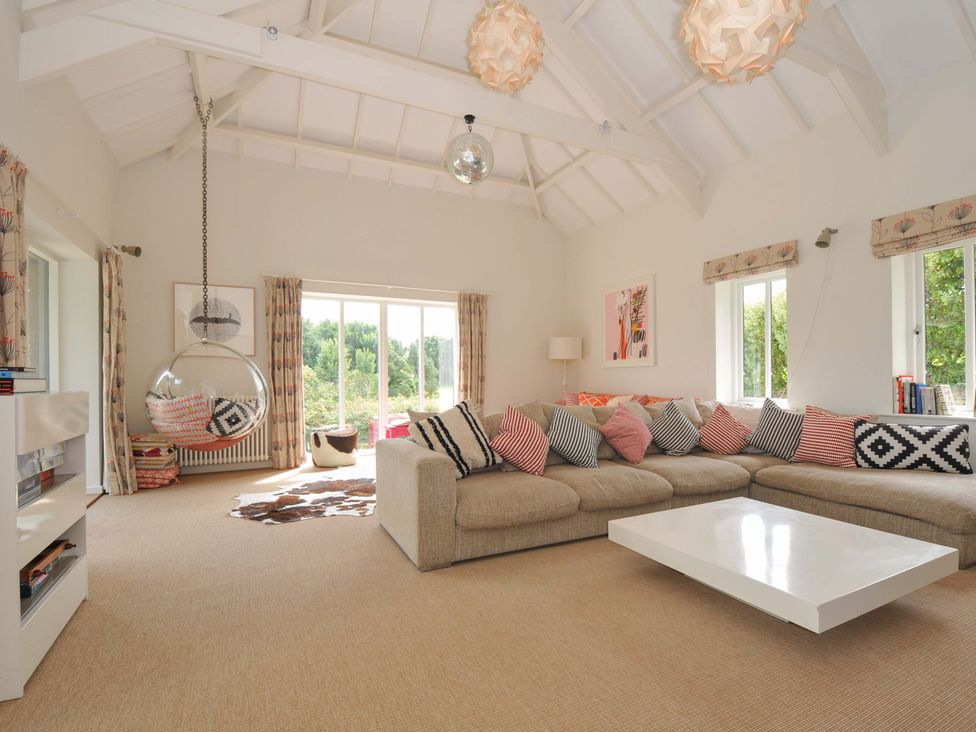 A living room with a sofa and hanging chair at The Old Granary in Rock