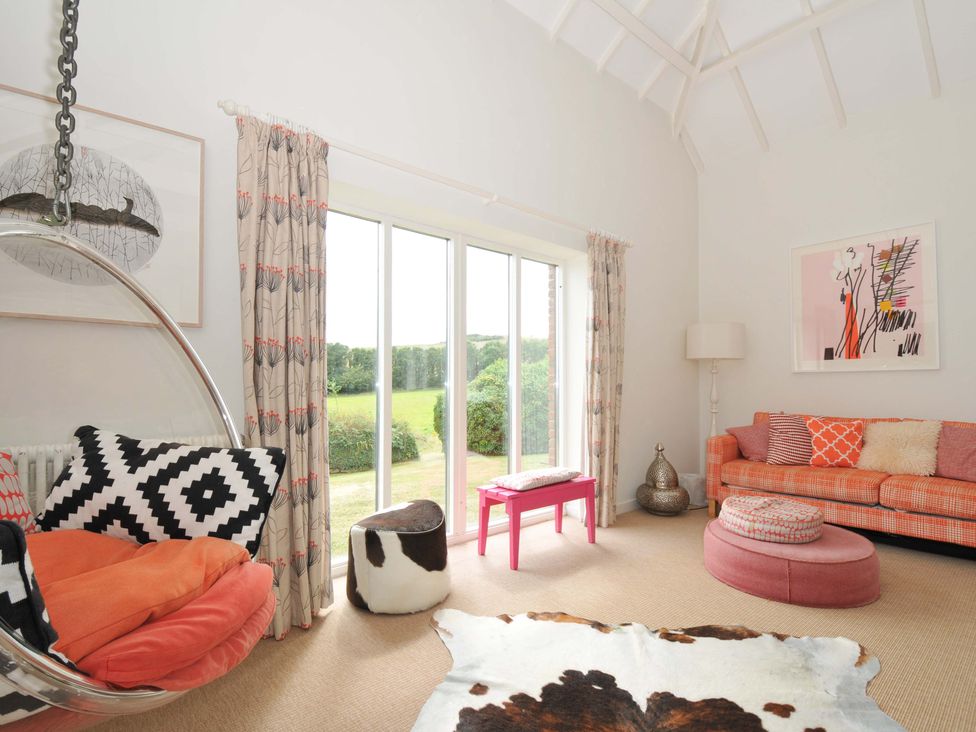A living room with a hanging chair and sofa at The Old Granary in Rock