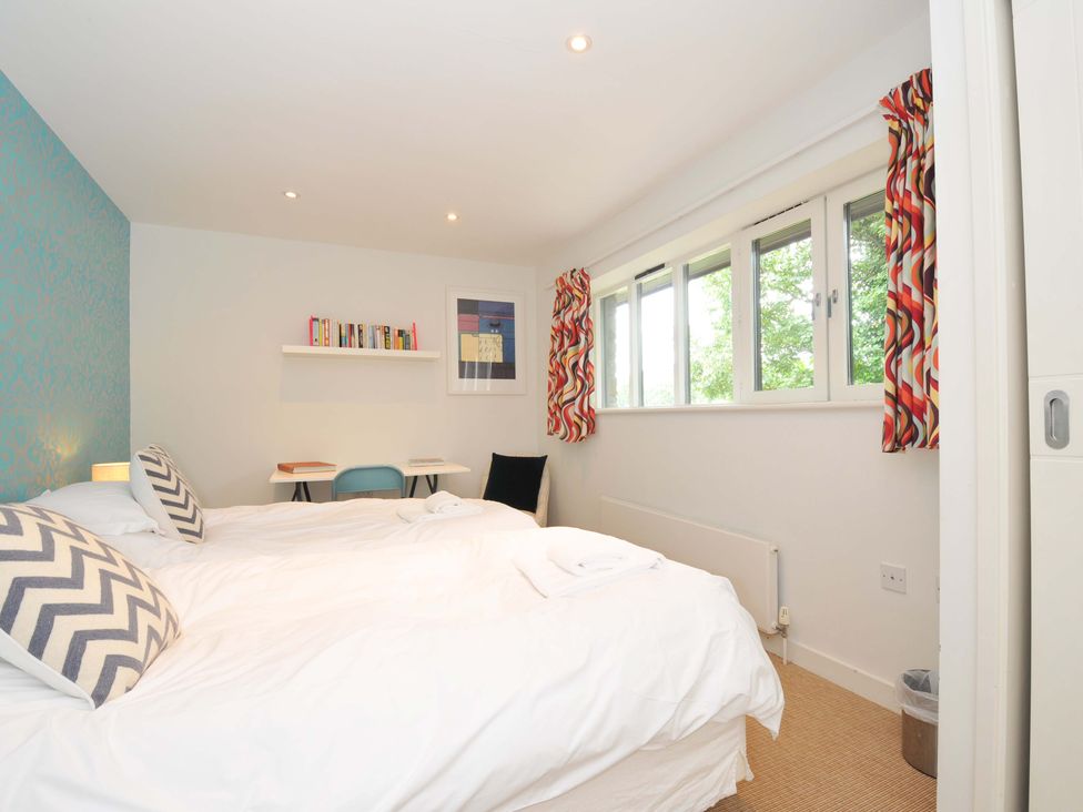 A bedroom with two beds and a small desk at The Old Granary in Rock