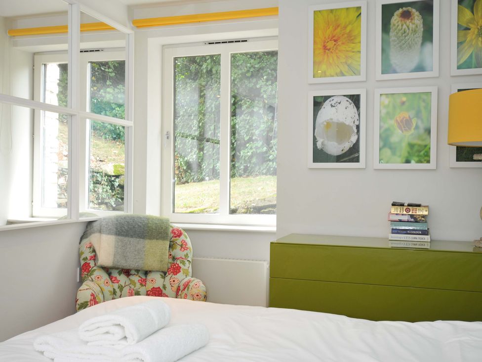 A bedroom with a bed, chair, and window at The Old Granary in Rock