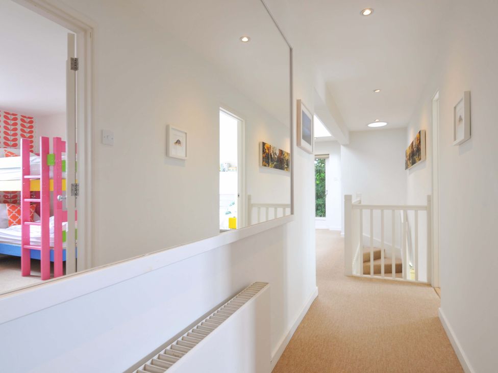 A hallway with a mirror and stairs at The Old Granary in Rock