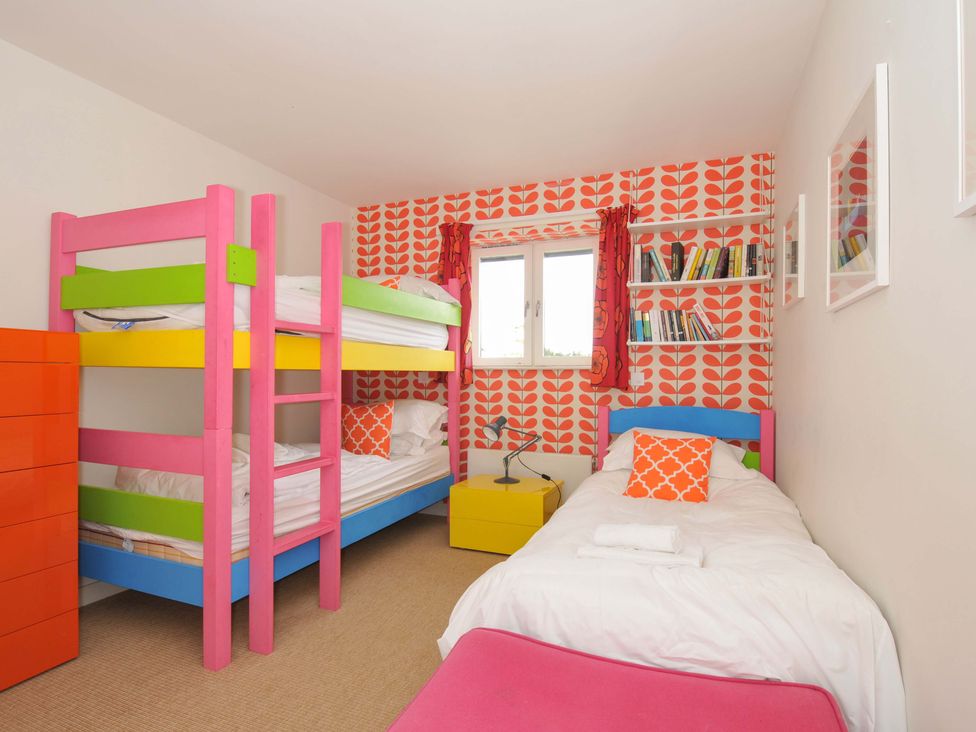 A bedroom with a bunk bed and a single bed at The Old Granary in Rock