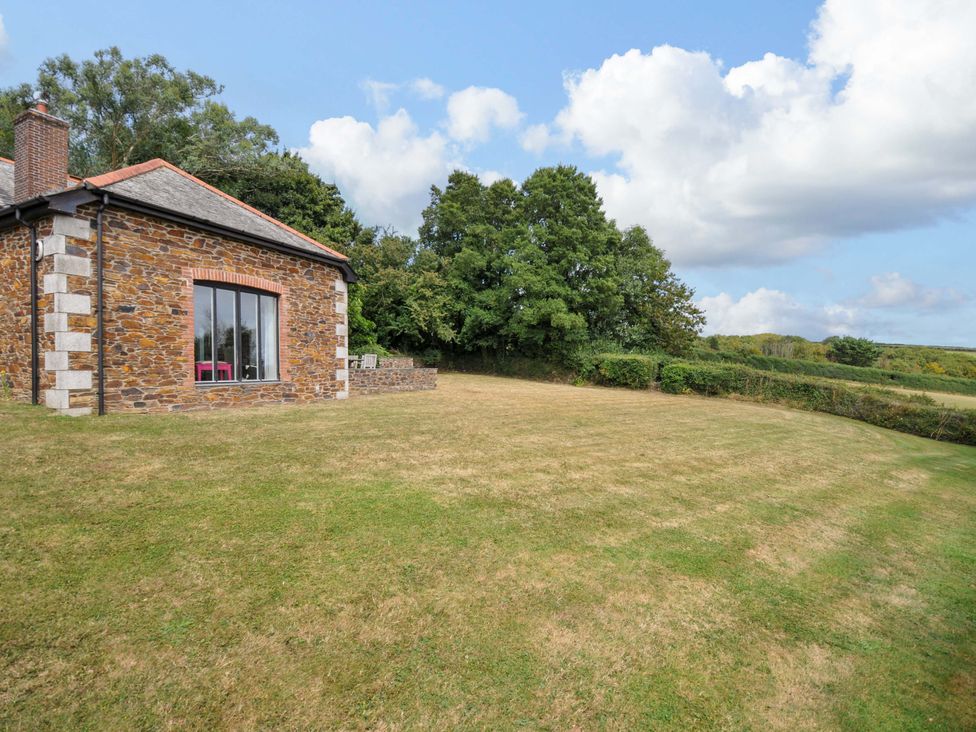 An outdoor view of a house with grass and trees at The Old Granary in Rock