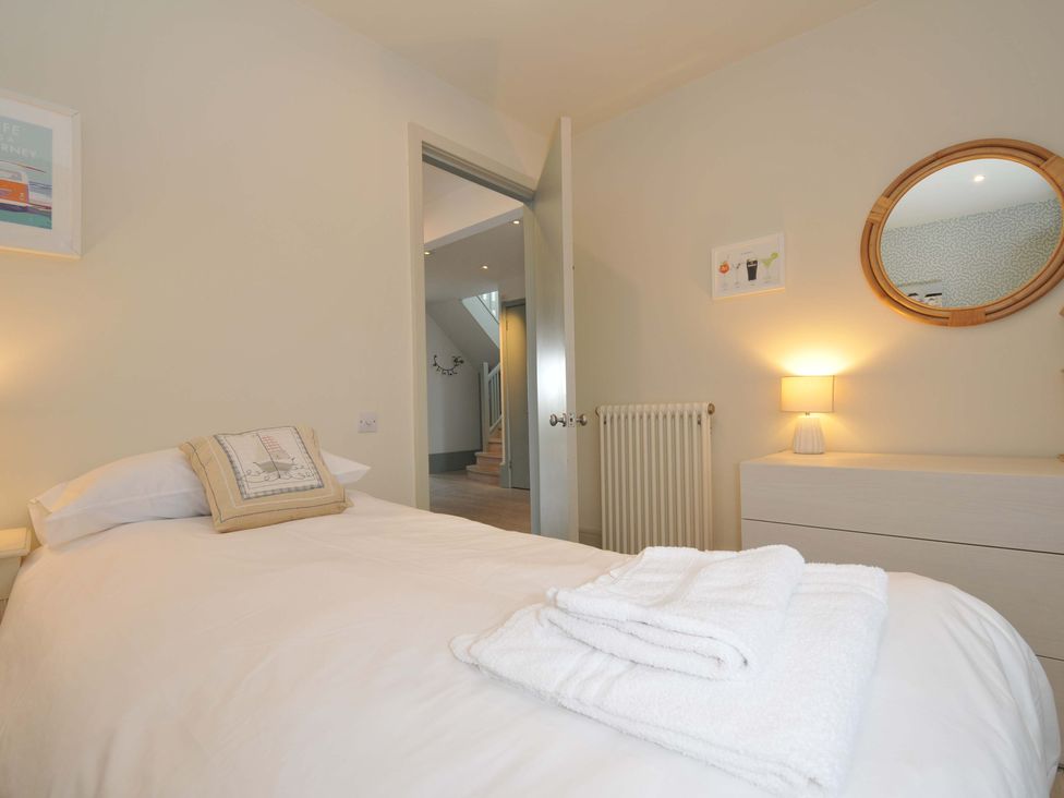 A bedroom with a bed and a lamp at The Point in Polzeath