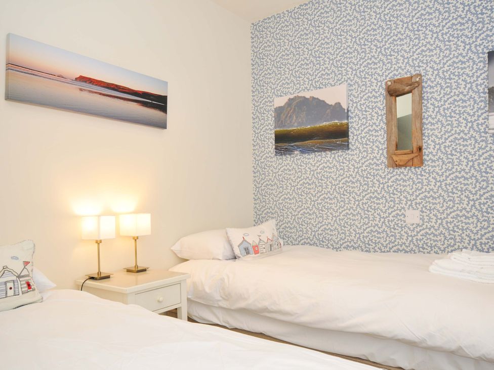 A bedroom with two beds and a lamp at The Point in Polzeath